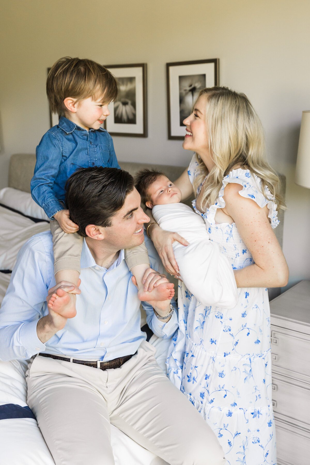family smiling together with newborn baby