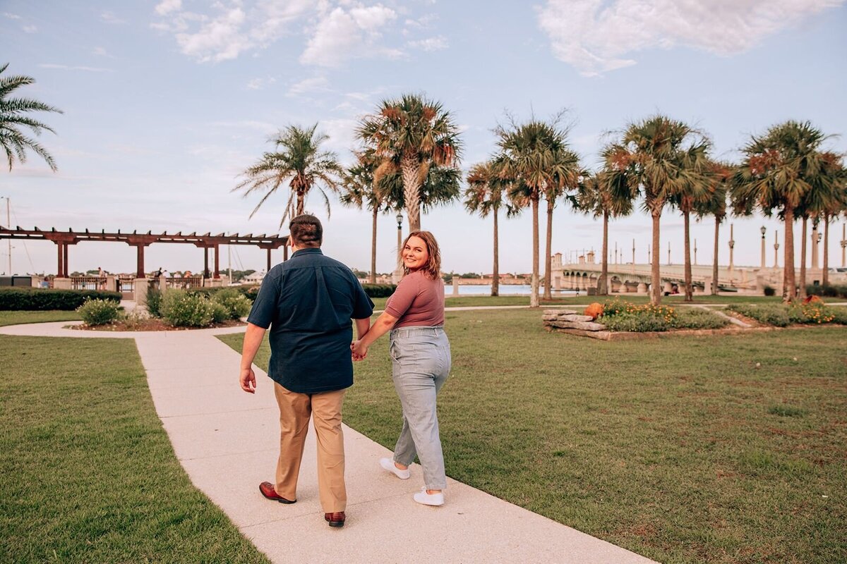 engaged couple walking along sidewalk in st. augustine florida