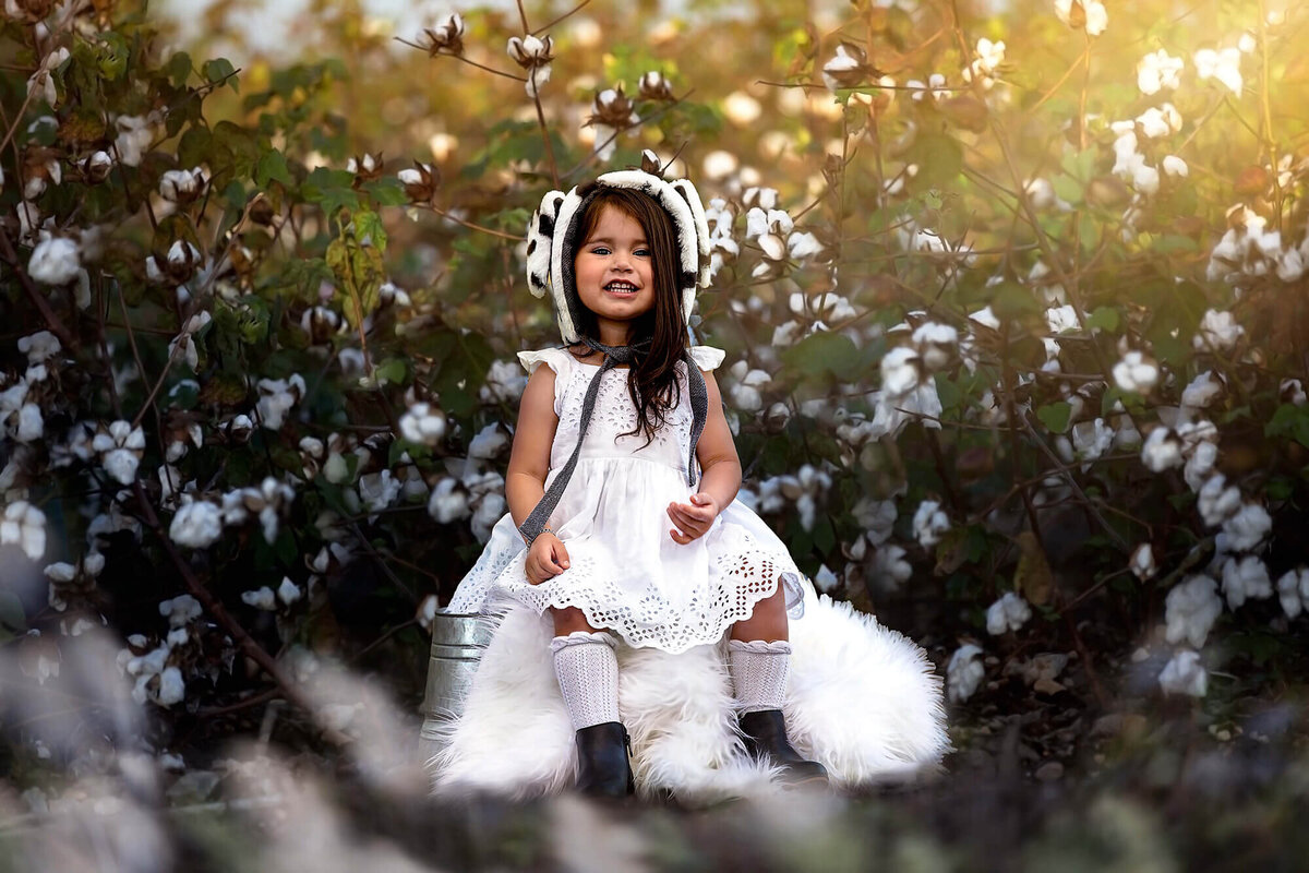 Sweet baby girl sitting in a field of cotton in Houston, Texas.