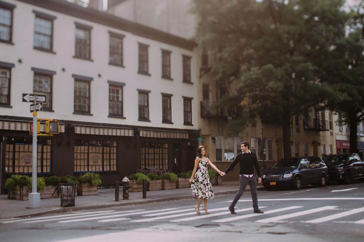 The fiancé is holding his fiancée's hand, leading her to cross the street in West Village, NYC. Image by Jenny Fu Studio.