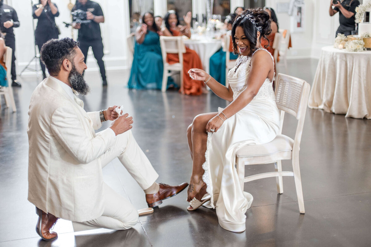 Fun and laughter as the groom removes the bride’s garter during the reception.