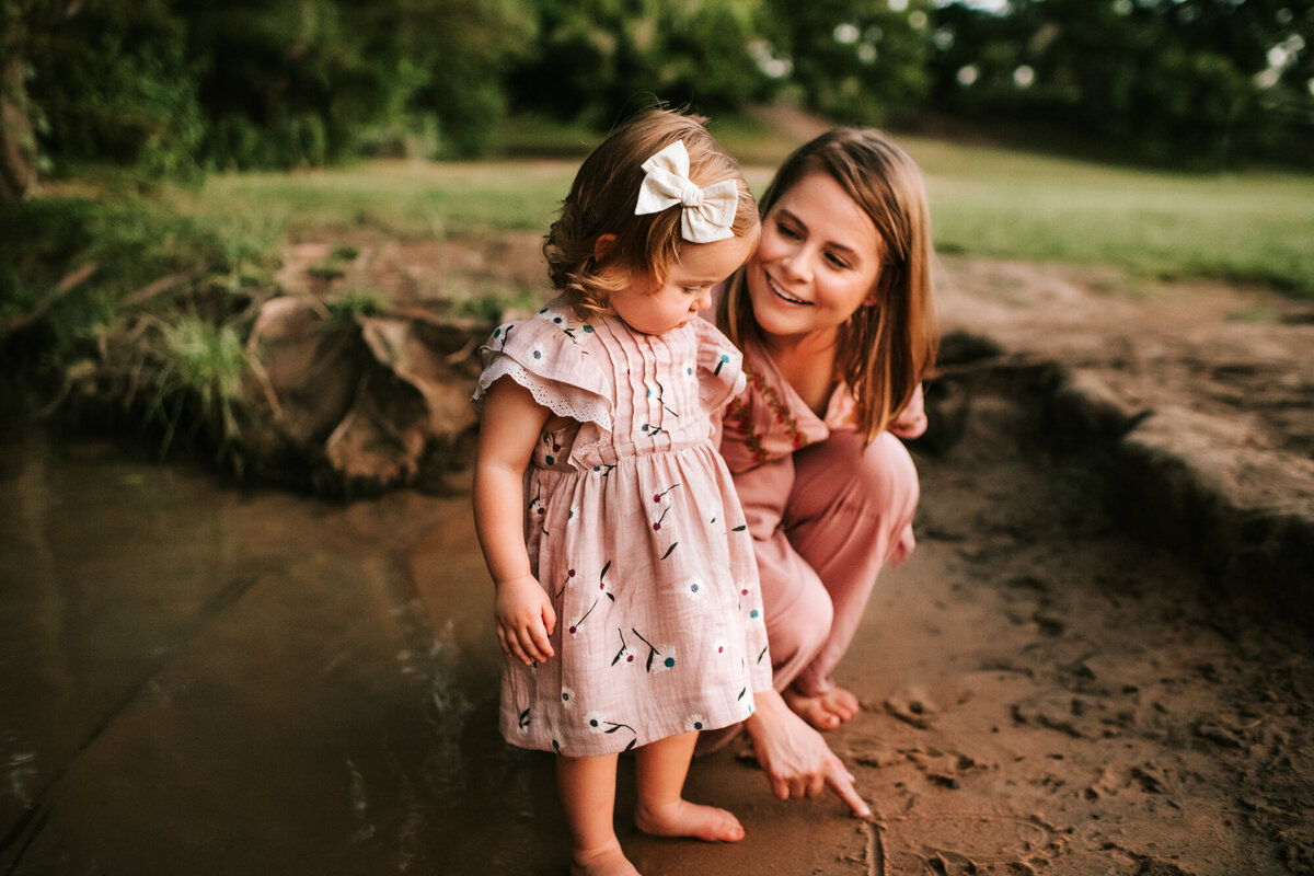 Mom playing in the sand with her daughter.