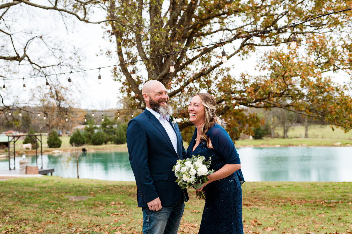Eloping couple laughing together under fall foliage