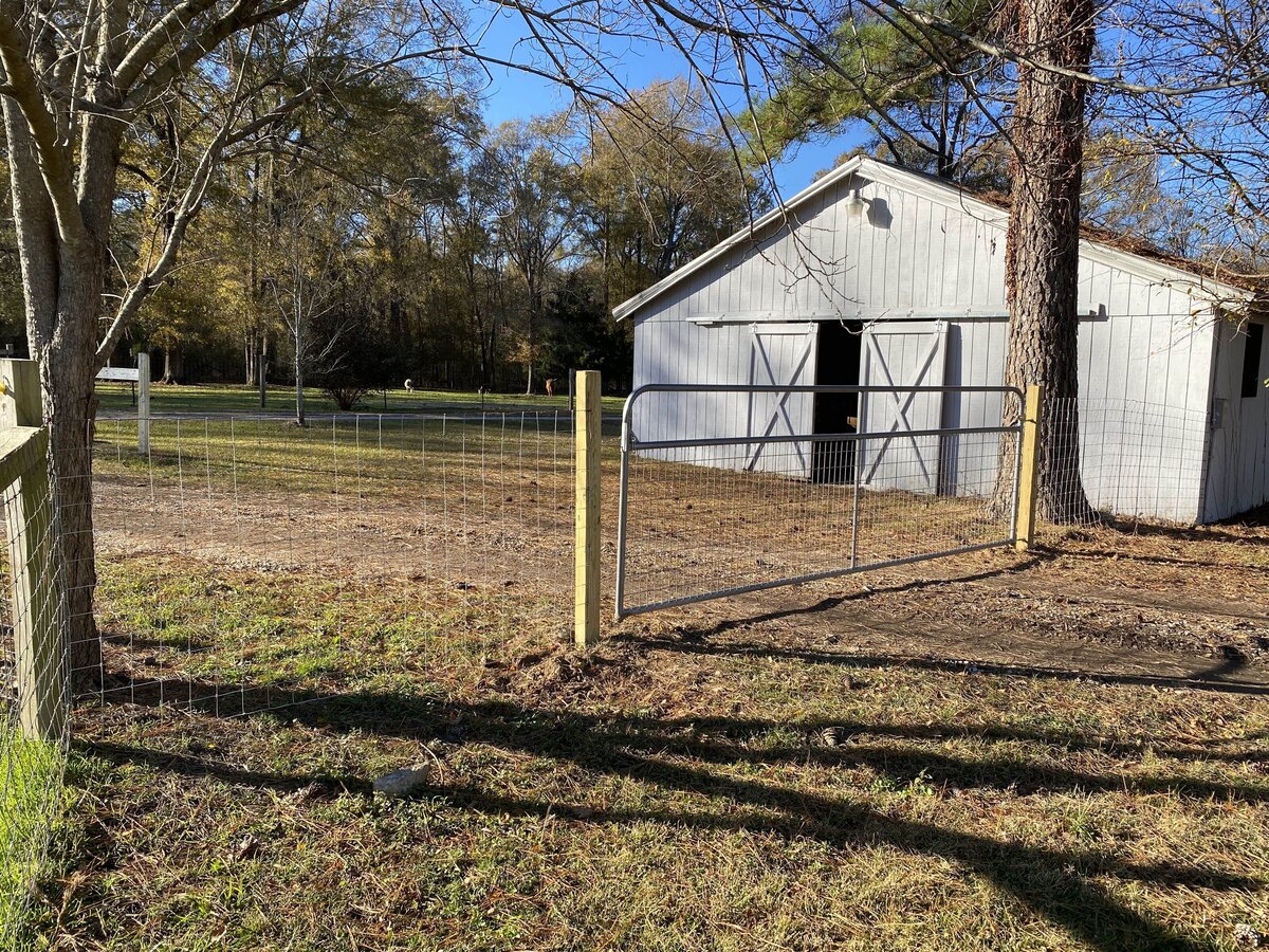 wood-and-wire-fencing-outside-of-white-barn