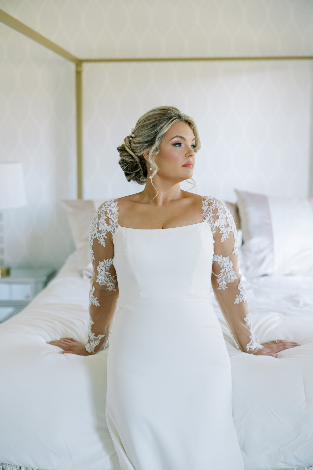 bride posing on a bed in her wedding dress