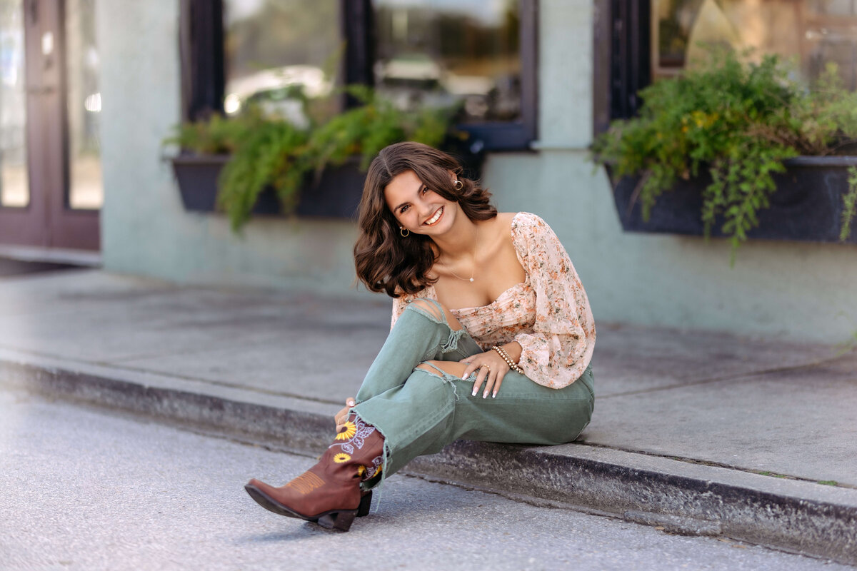 Confident senior pose in city alley with dark tones and clean lines