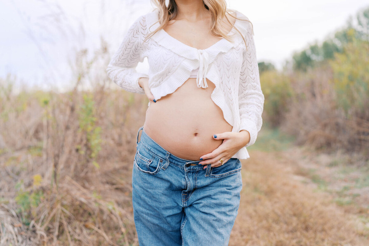 pregnant woman holds belly at seven islands state birding park in kodak tennessee