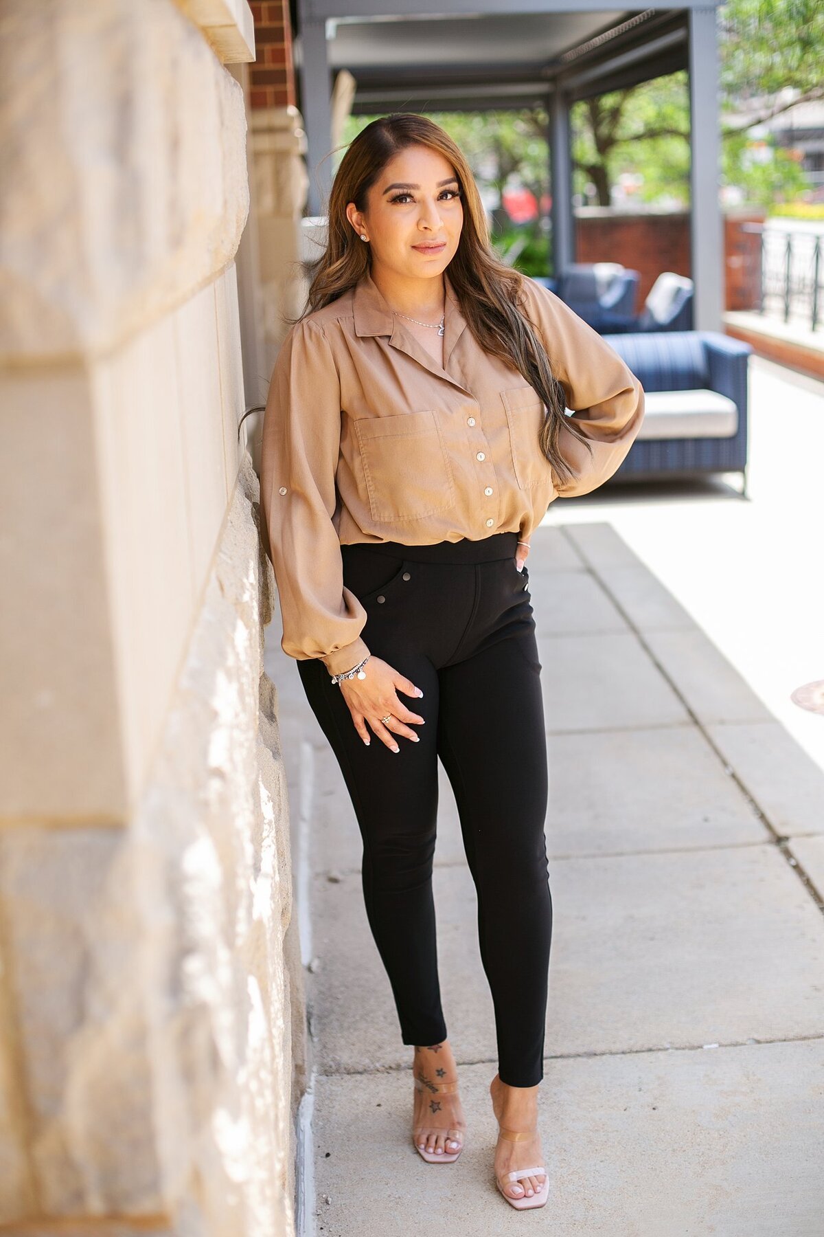 A-young-businesswoman-in-a-neutral-blouse-posing-against-a-stone-wall-during-a-modern-headshot-session-in-downtown-Indianapolis