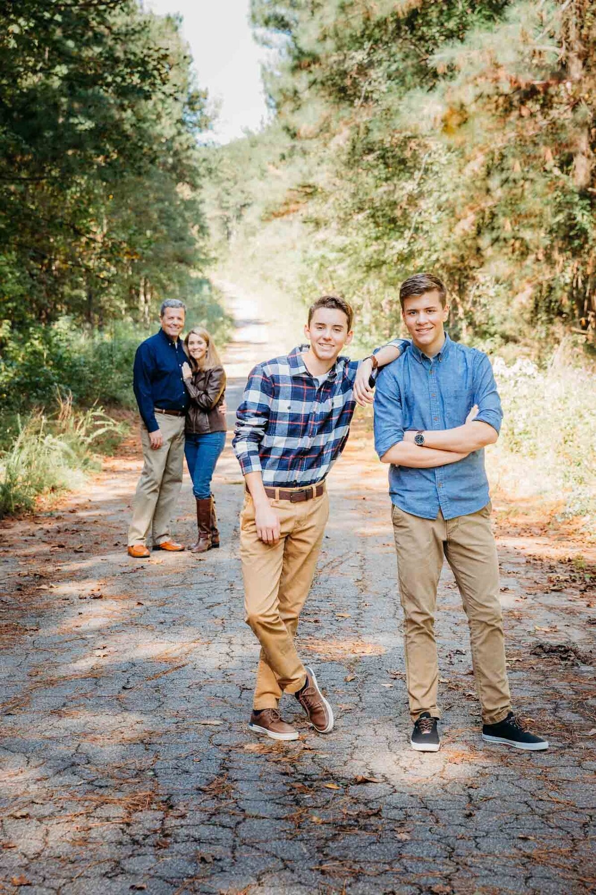 Mom and dad in the distance with the focus on their two  sons in the front leaning on one another.