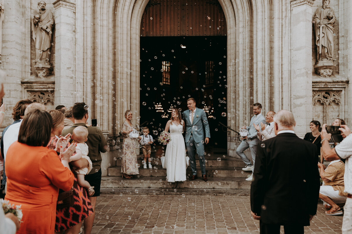 Bruidspaar wandelt uit kerk door bellenblaas.