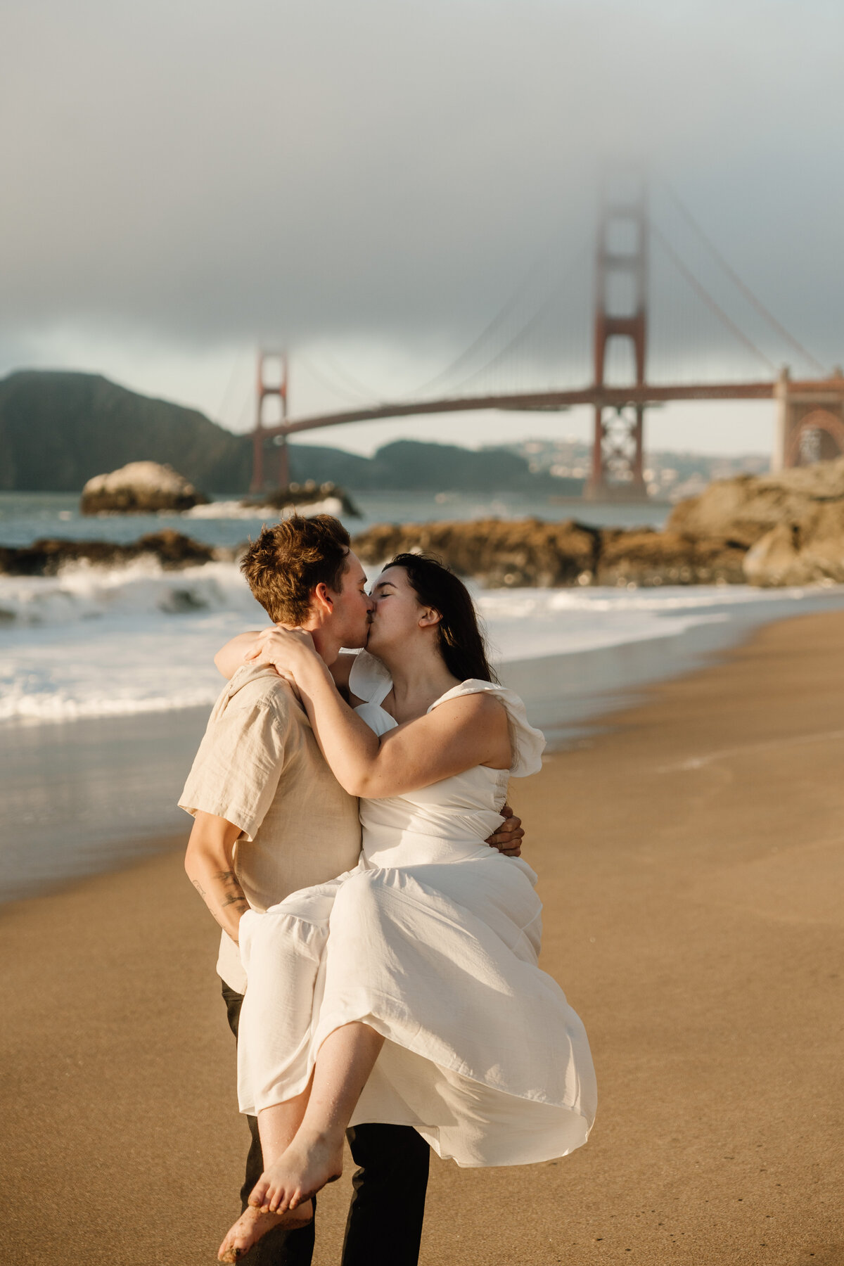 couple kissing in san francisco with golden gate bridge