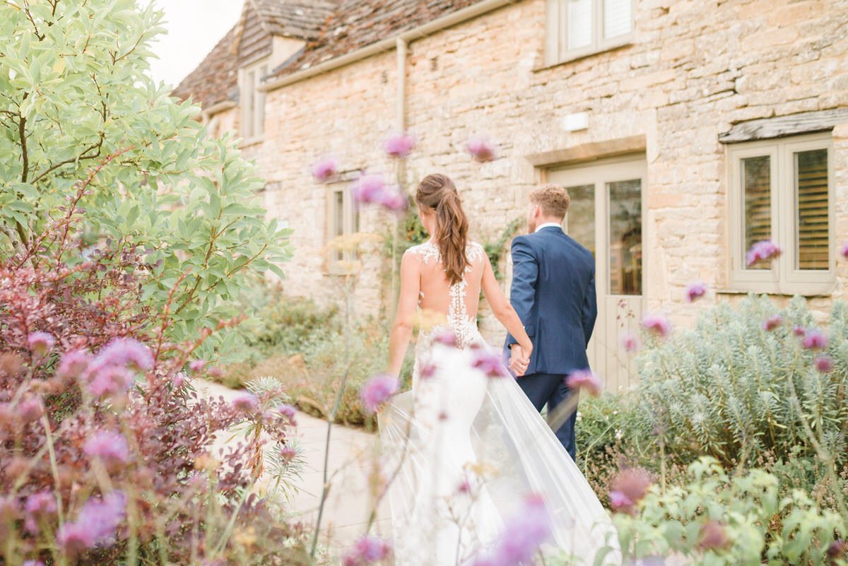 caswell-house-newlyweds-walking-summer-flowers-blooming Hannah McClune Photography