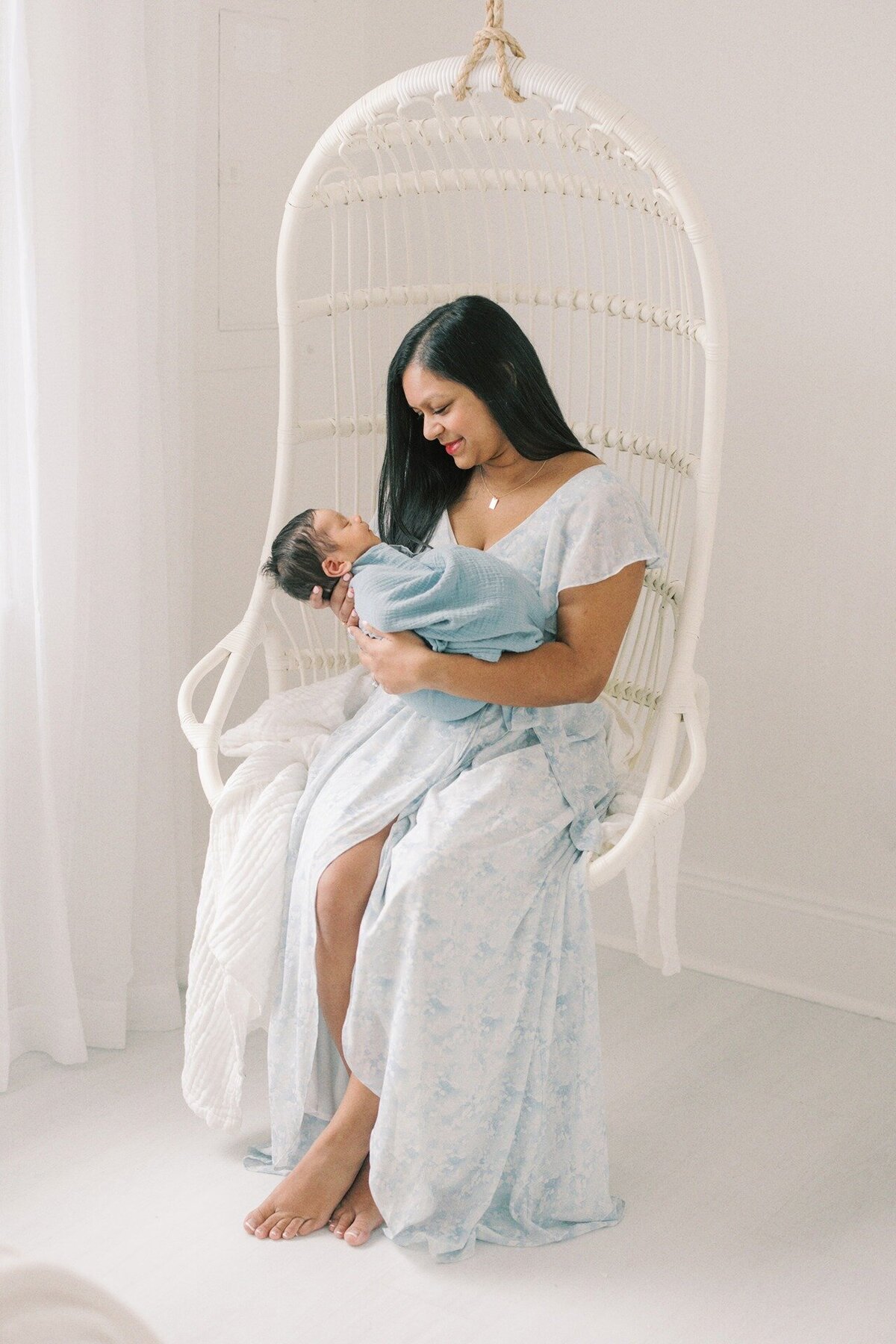 mom-holding-newborn-in-wicker-swing