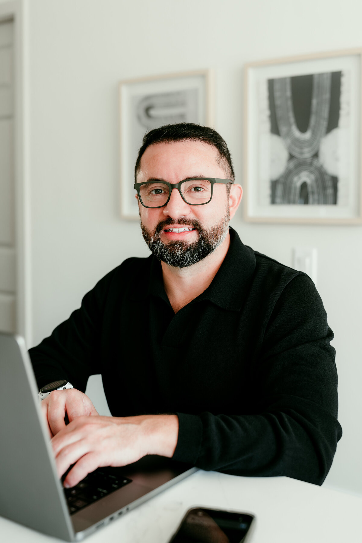 Lifestyle dating profile photo of a man working from his home office in Minneapolis, showing hobbies and personality for dating apps.