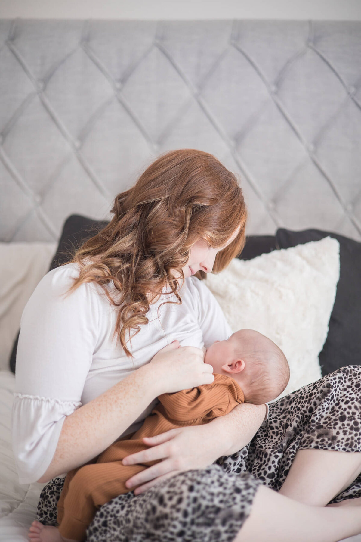 beautifu lredheaded new mom breastfeeding her infant son