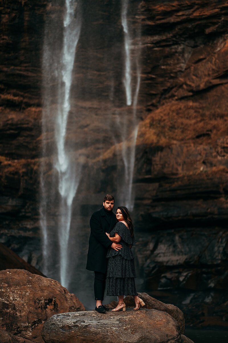 couple posing near waterfall