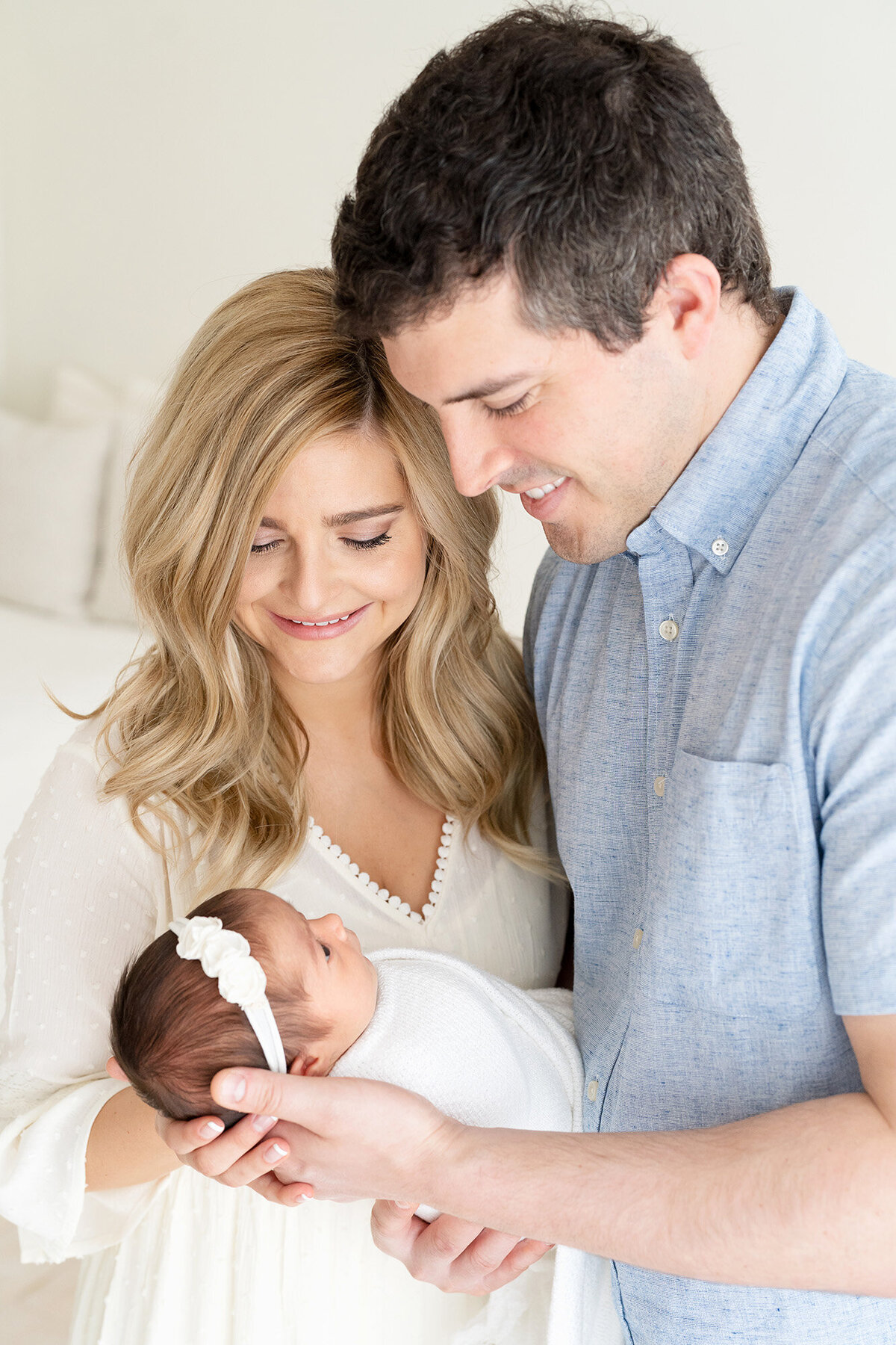 Louisville KY couple smile at newborn baby girl for photos at Julie Brock Photography Studio