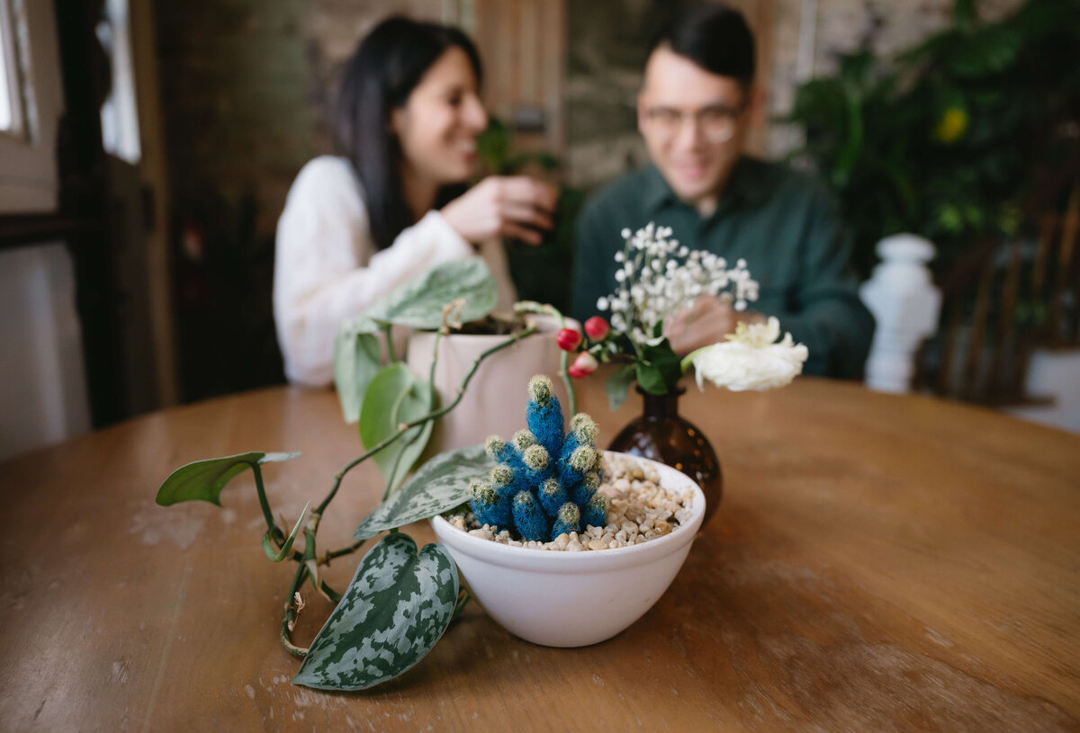 Virginia wedding photographer captures details of a coffee shop with man and woman in the distance sharing coffee and laughs