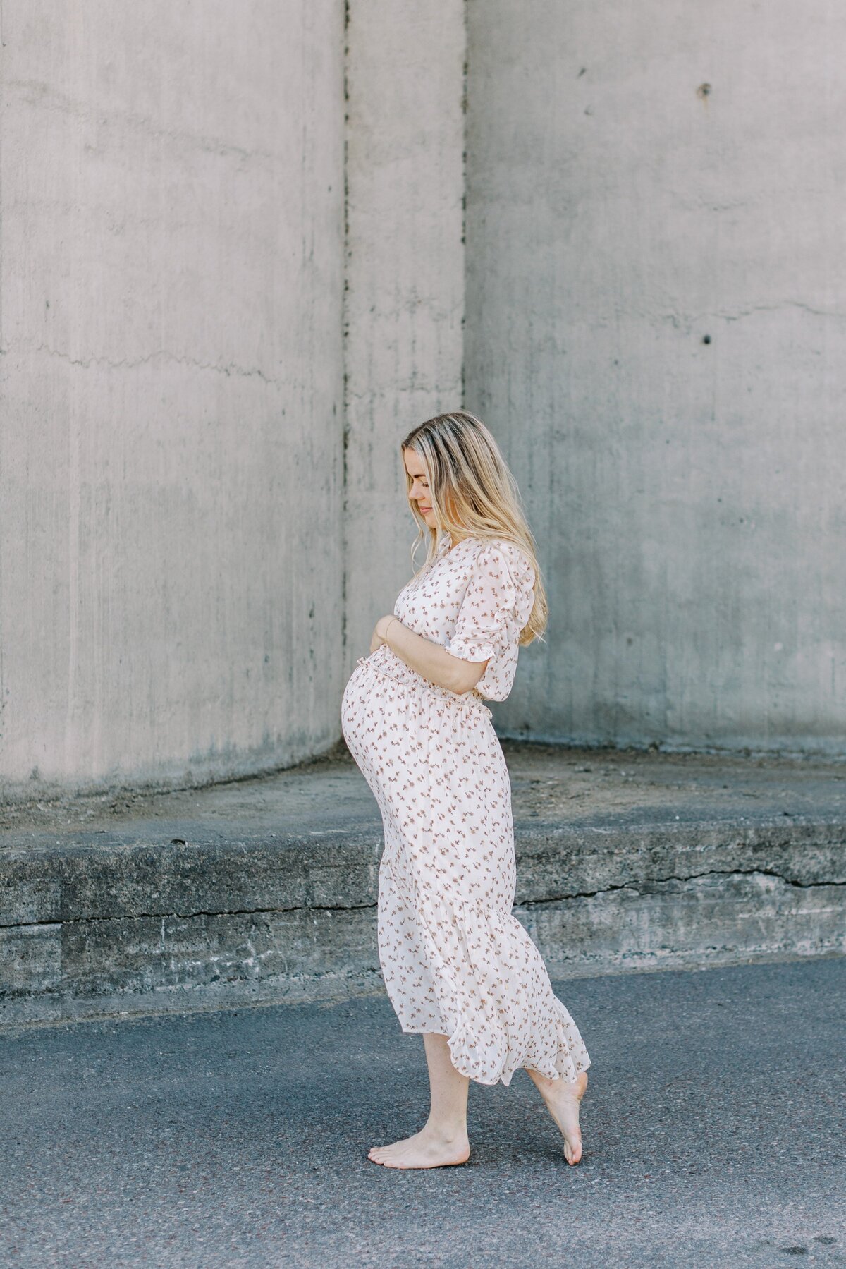 Gravid i lång klänning i profil i Västerås