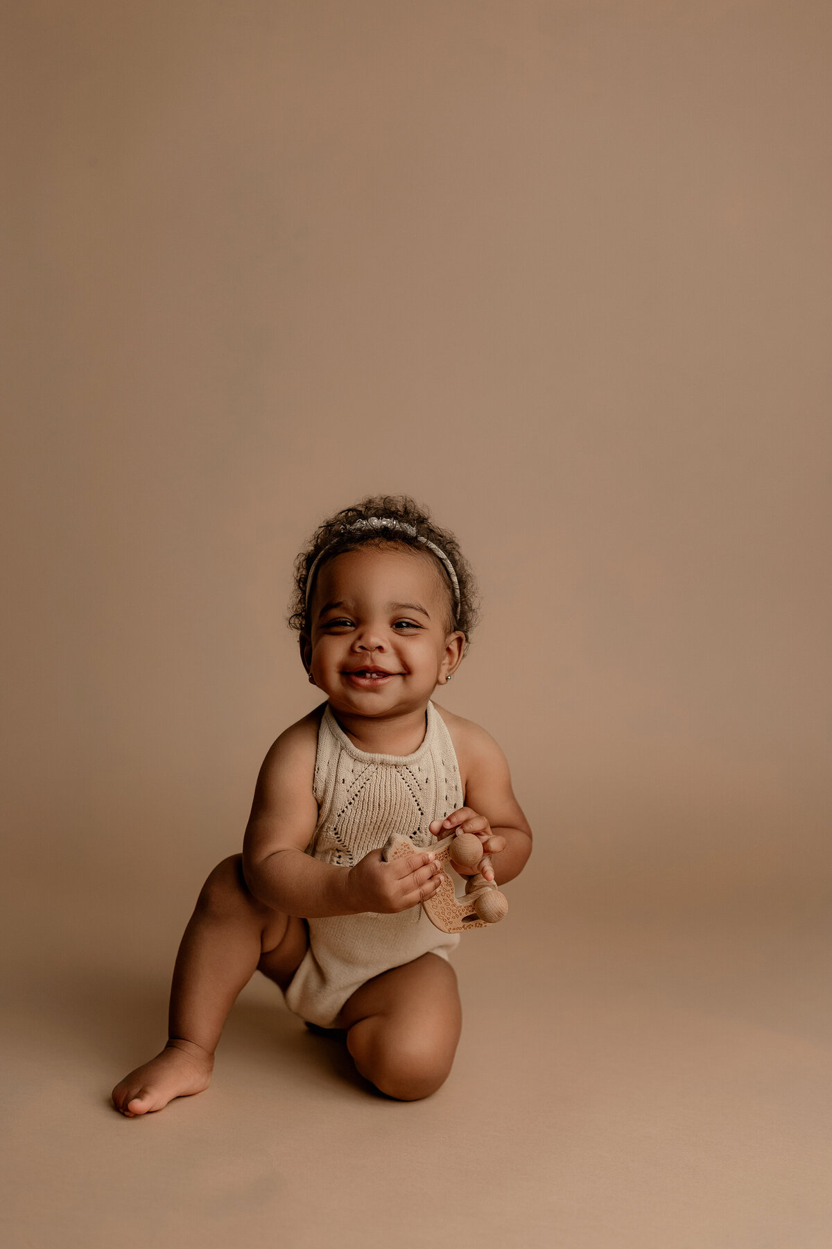 baby smiling on brown backdrop in phoenix milestone session