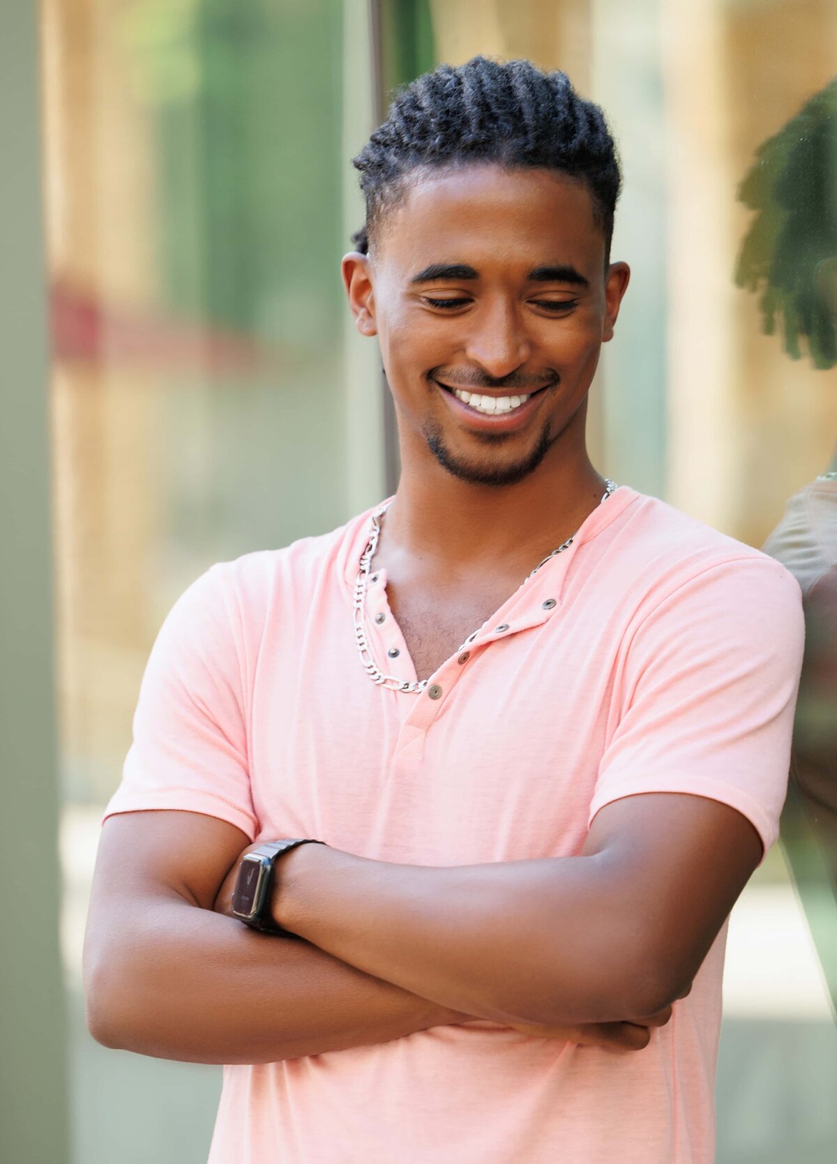 College graduation photoshoot of a young man laughing  in a peach shirt at Santa Clara University