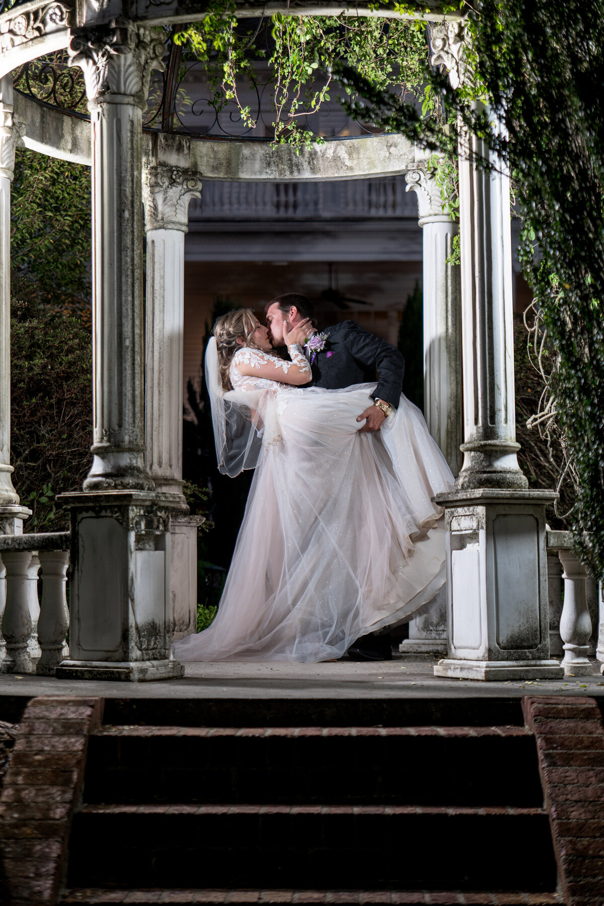 a person dipping their partner and kissing them in the middle of a gazebo 
