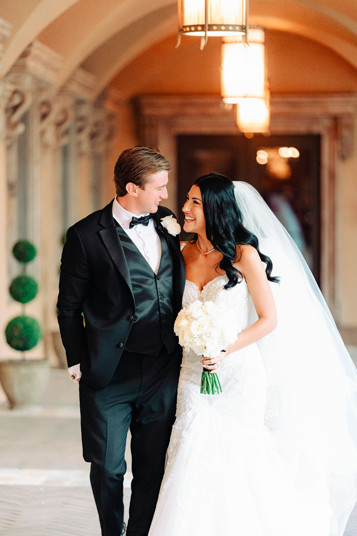 Bride & groom walking together for a photo at Scottsdale wedding Royal Palms.