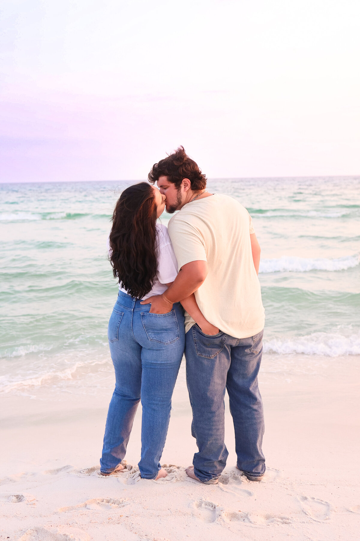 couple standing on beach kissing in panama city beach florida