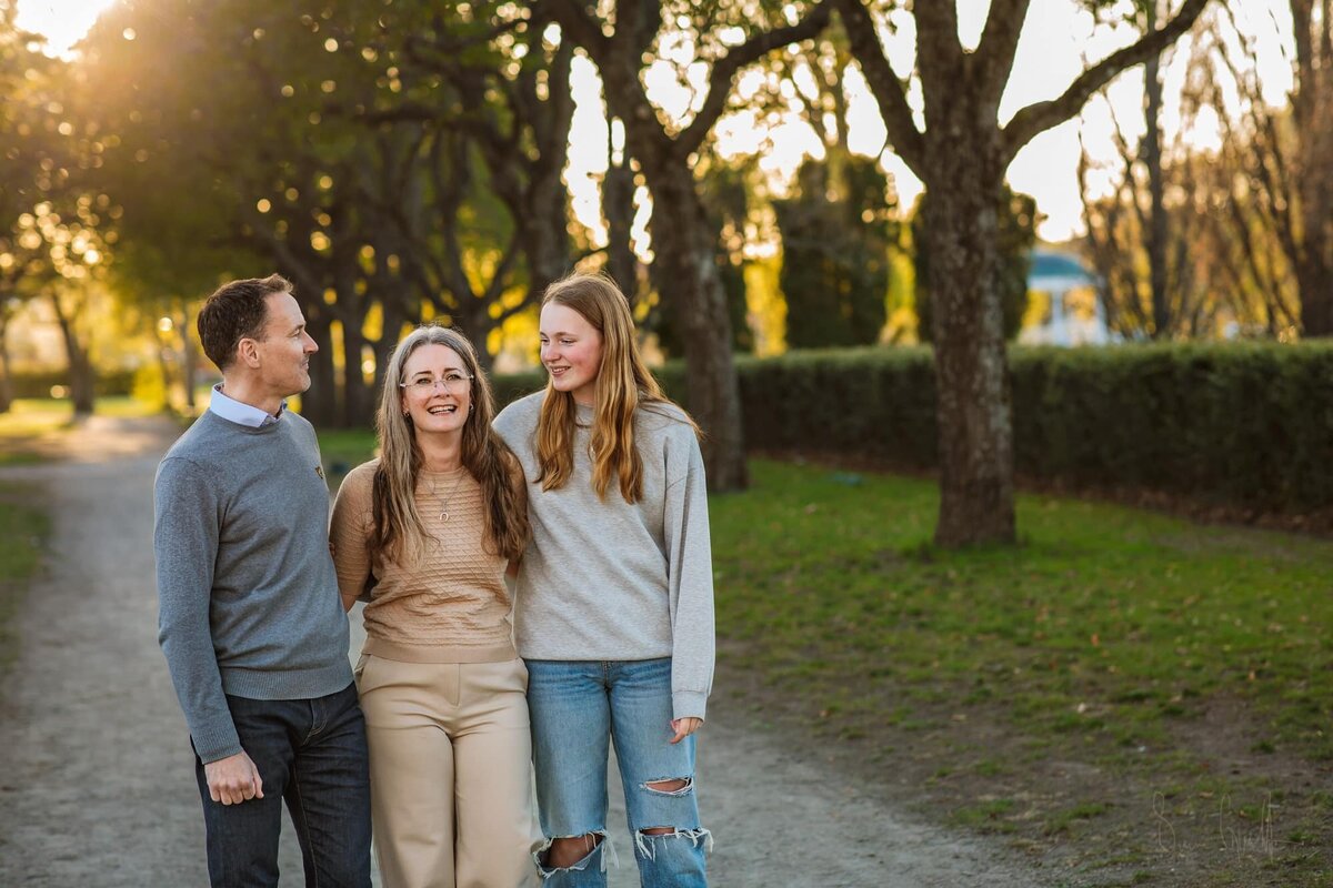 liten flicka sitter vid ett träd i skogen, under en sagolik fotografering utomhus