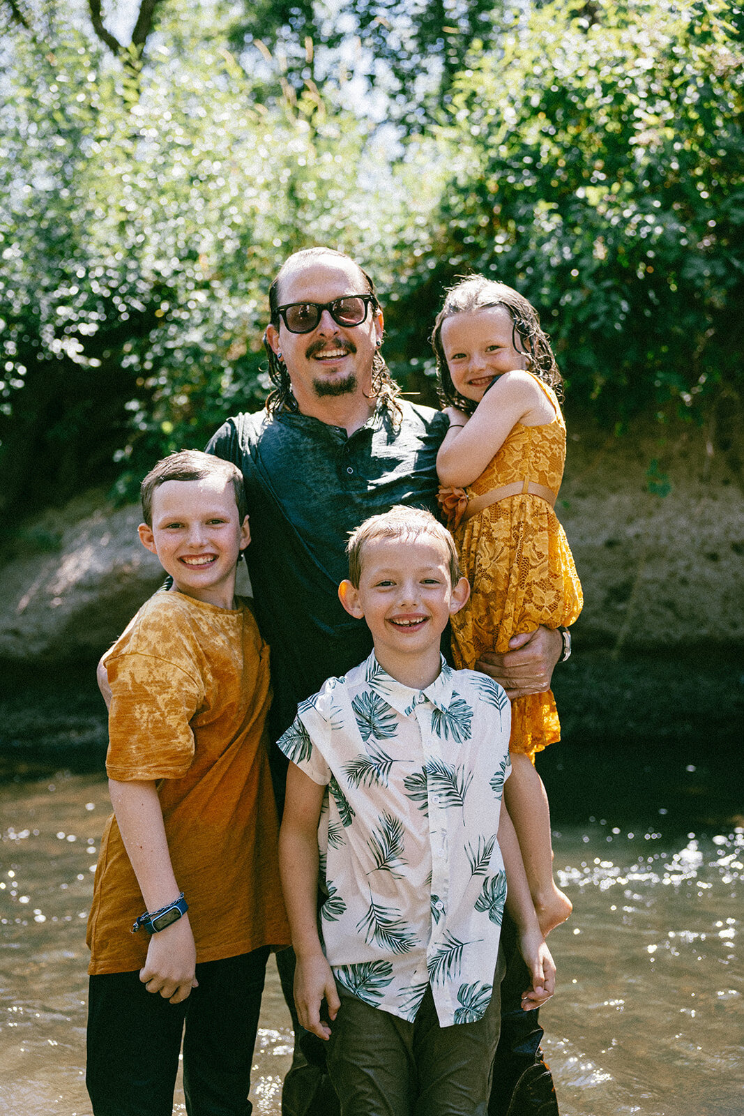 Family poses in the sunlight while taking family photos. 