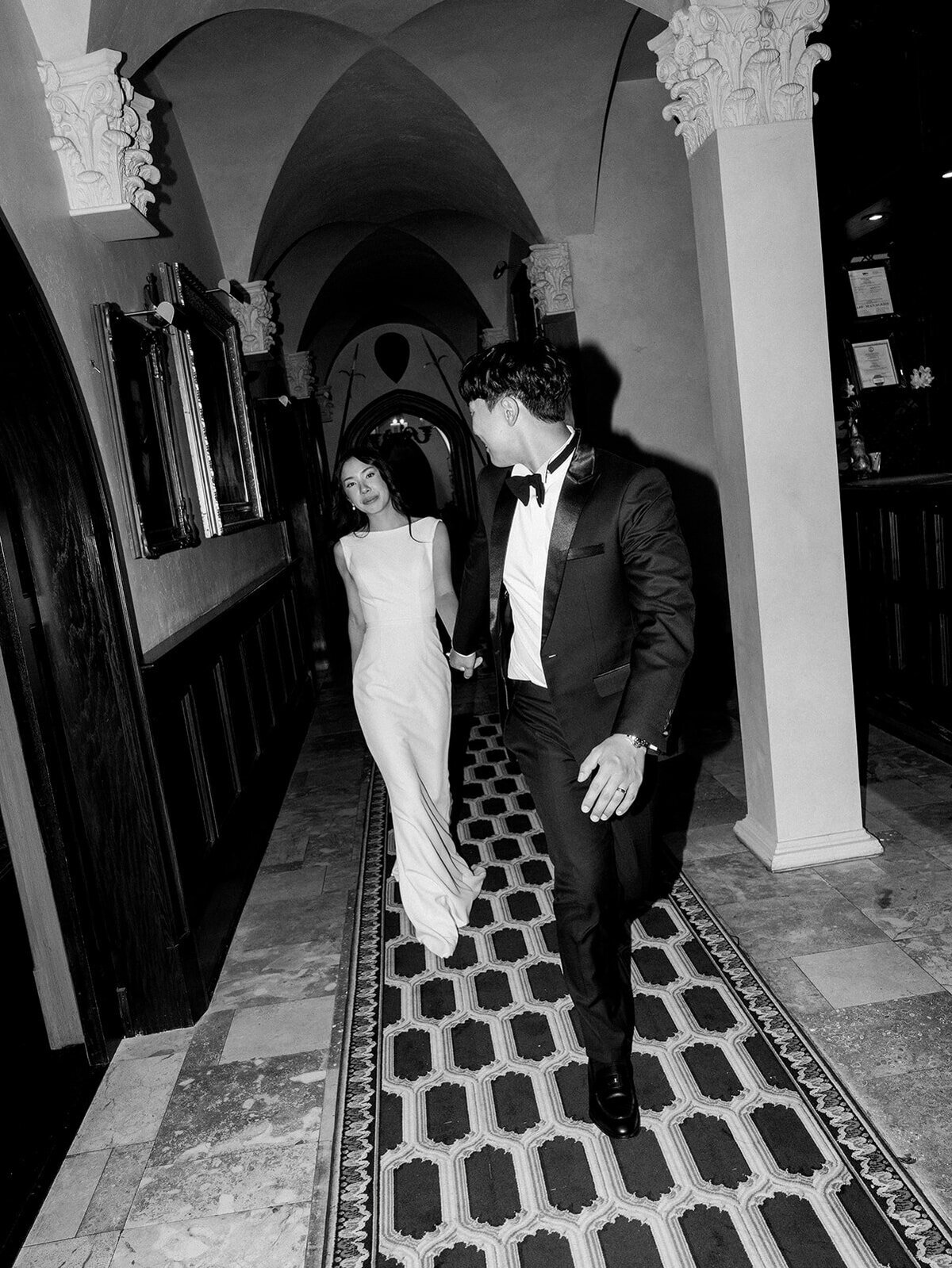 bride and groom walk around their venue and look at each other in a blurry modern image