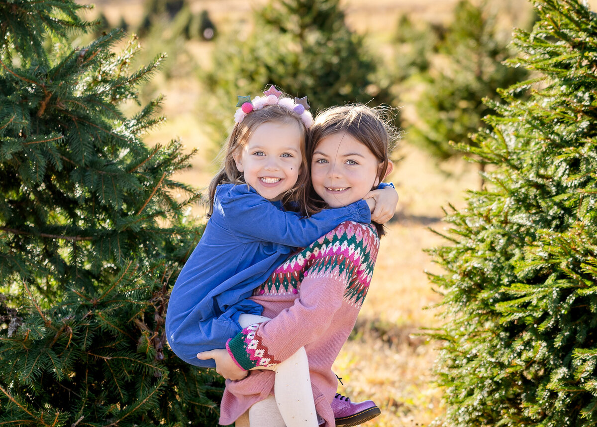 Siblings hugging at a Christmas tree farm in Somerset County, NJ