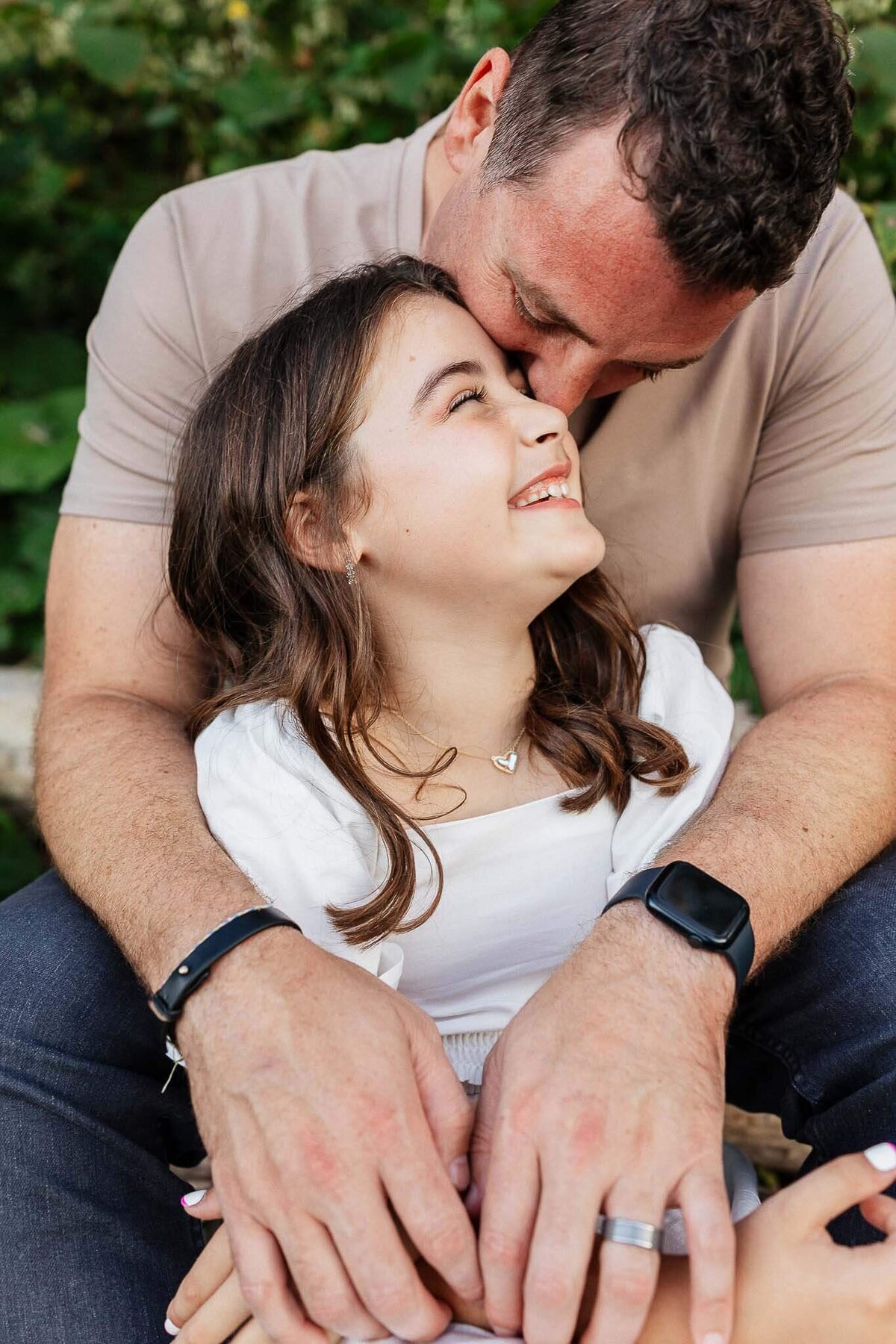 Father hugging daughter during family photography session at Huntington Beach in Bay Village, Ohio.