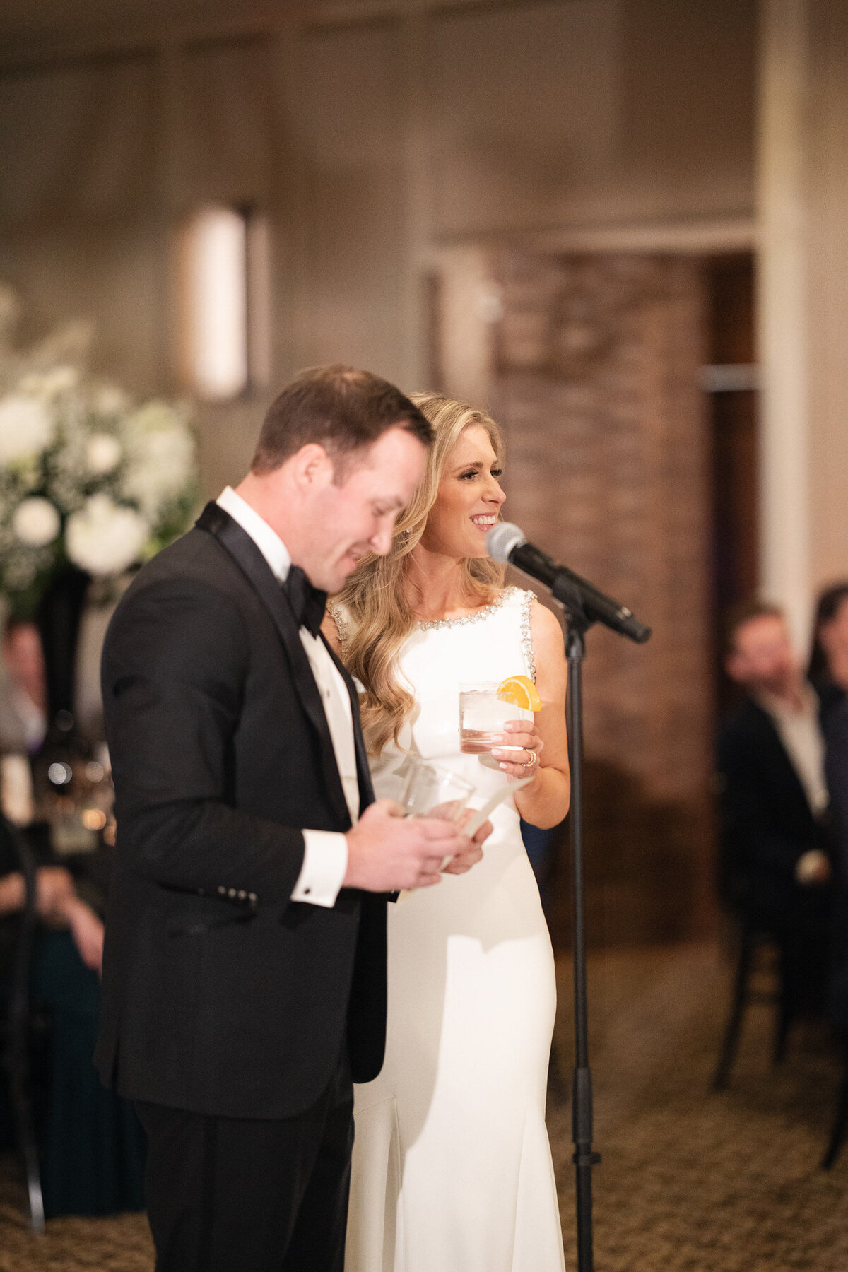 Bride and groom giving thank you speech at wedding reception