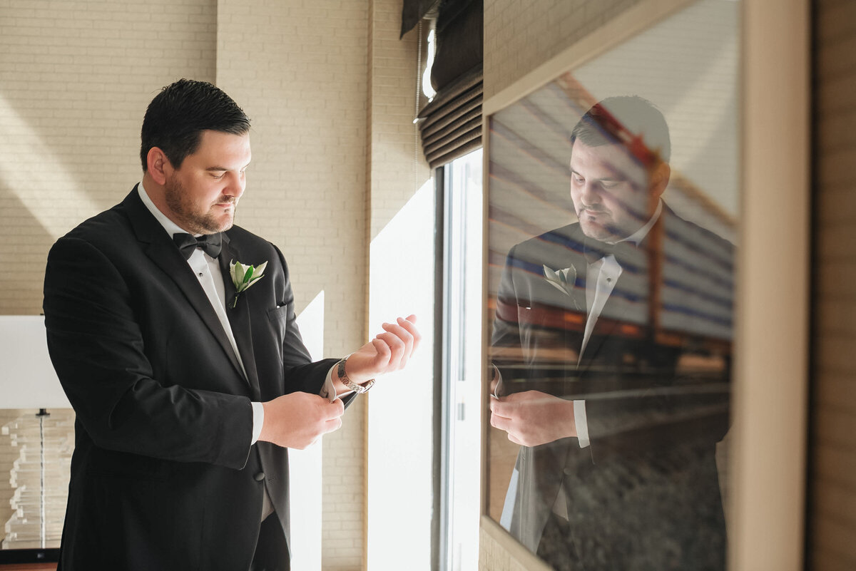 groom getting ready at The Adolphus in Dallas, captured in a classic and elegant portrait highlighting wedding preparation at the venue.