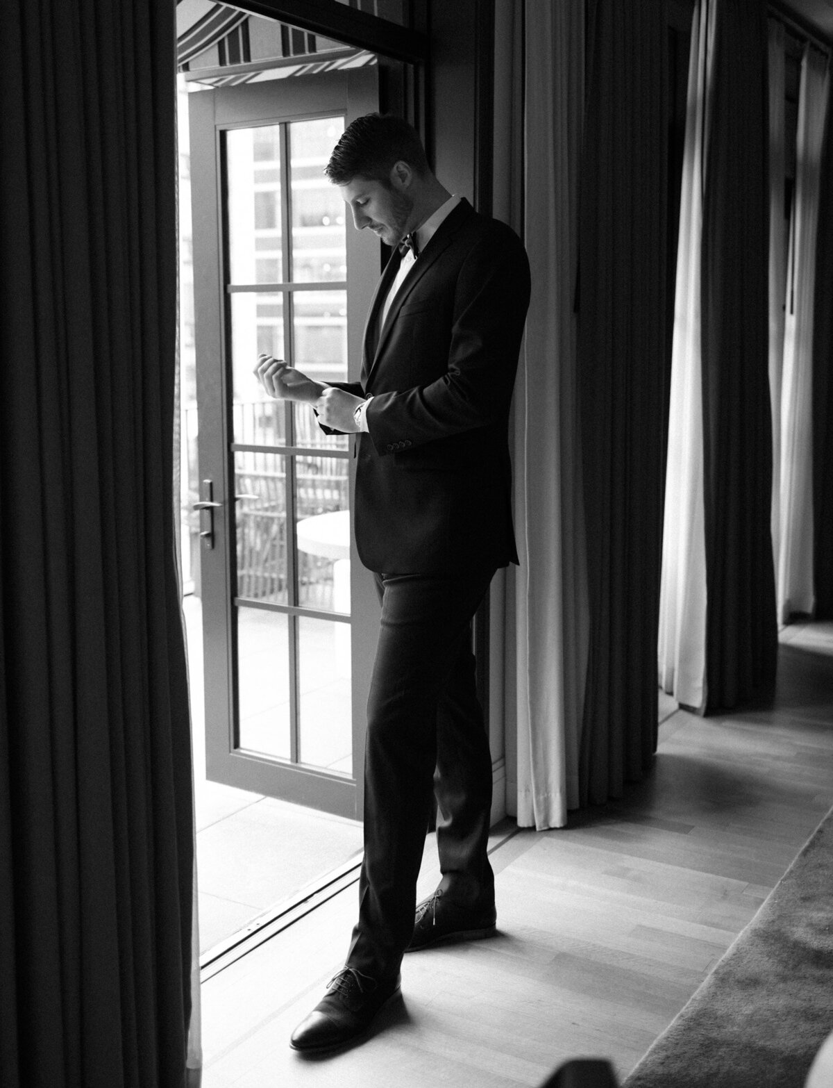 tall groom fastens cufflinks at Shinola Hotel