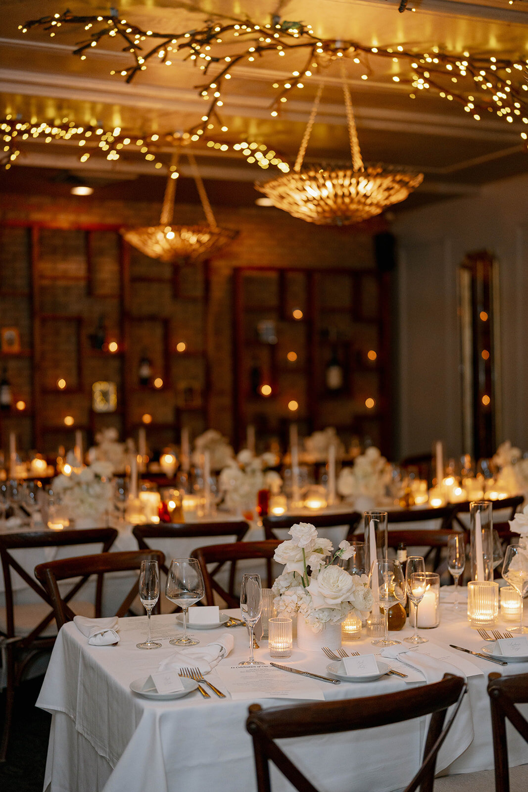 Elegant dinner table setup at Café Cortina in Farmington Hills Michigan, candlelit Italian-inspired reception décor with soft neutral florals.
