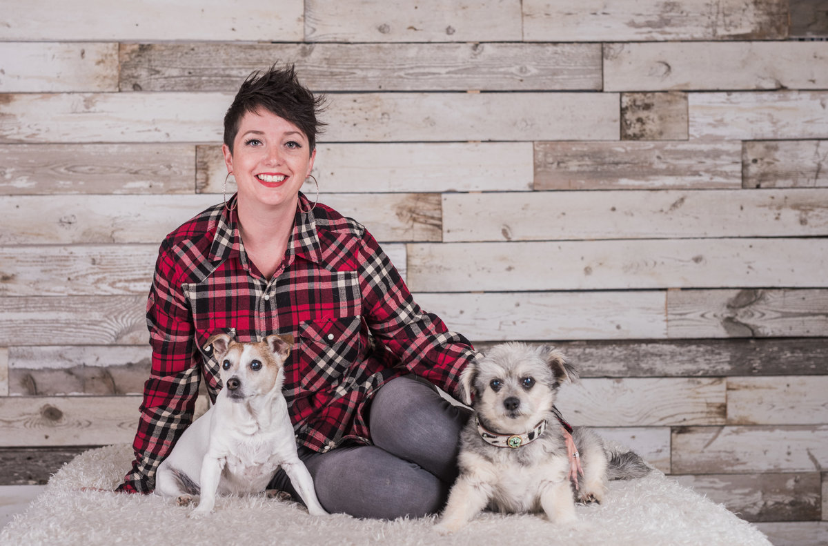 photo of woman with her two little dogs in studio on white blanket