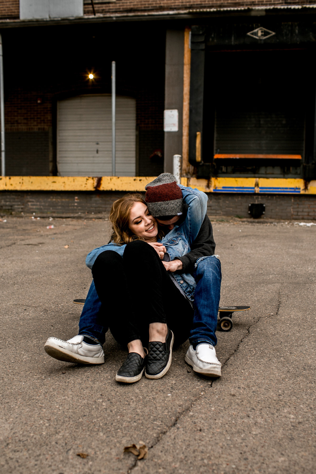 Couple cuddled up on a skateboard in Minneapolis, Minnesota.