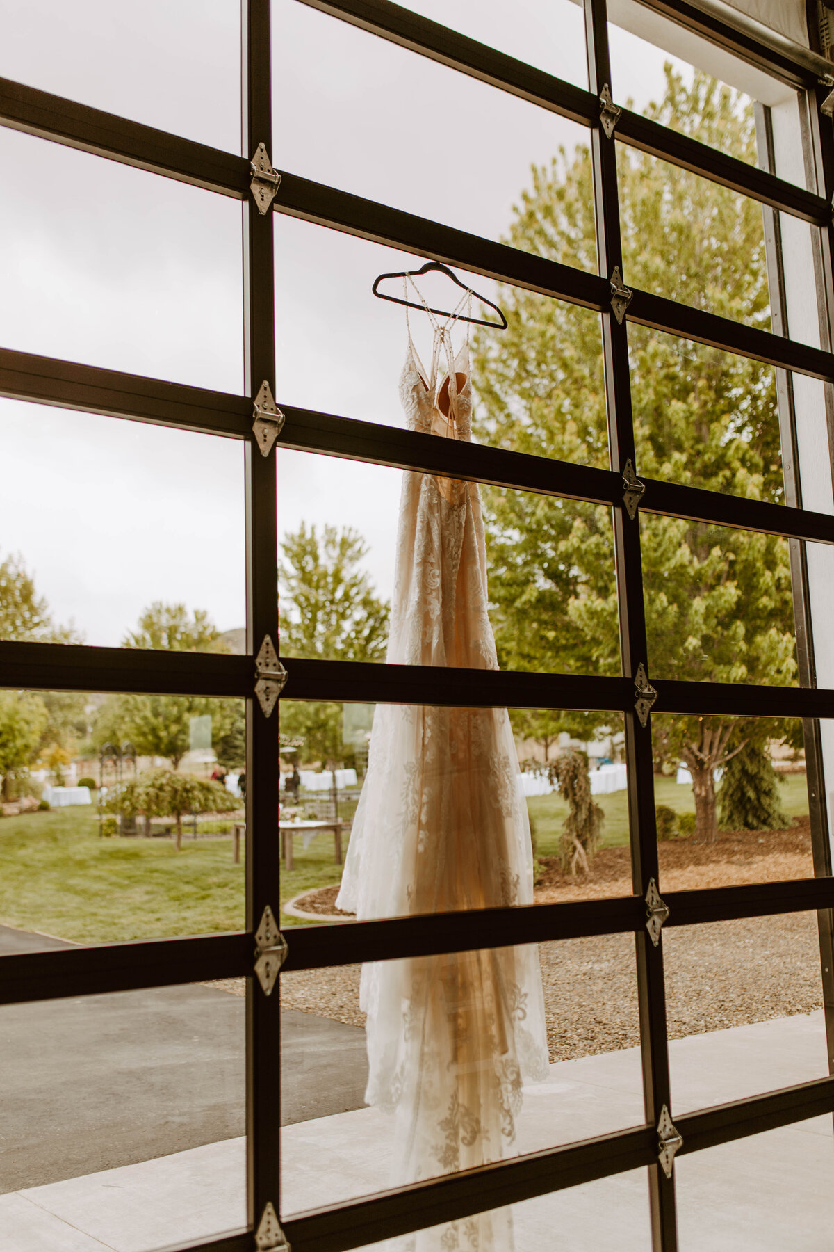 Inside looking out through glass of the wedding dress just hanging there. Bravo, photographer, bravo.