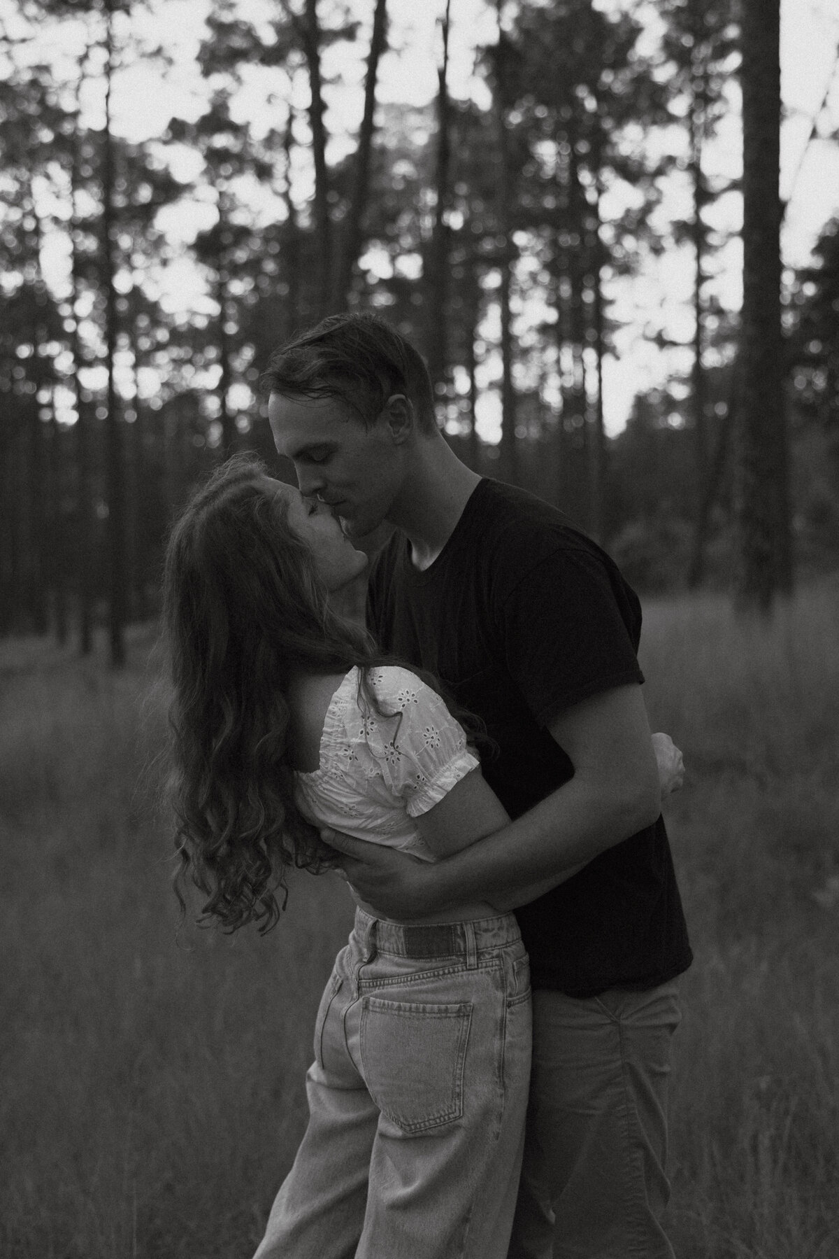 Couple posing for portraits in a forest.