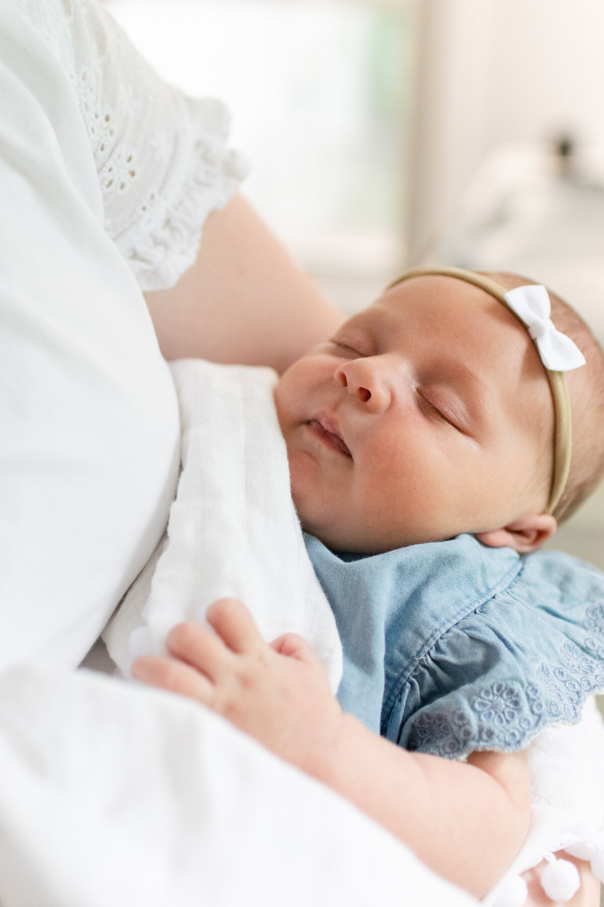 Newborn baby in Douglas, MA sleeping in mom's arms