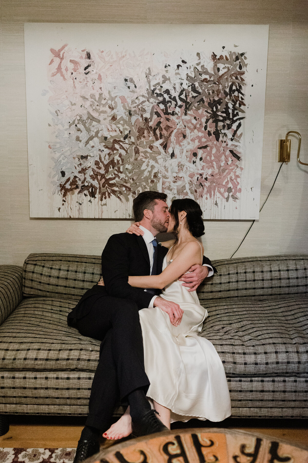 Bride and groom kissing on the sofa at Proper hotel Austin