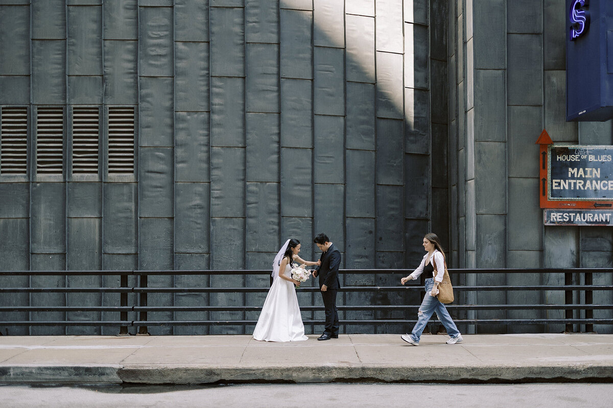 Candid moment of a bride and groom crossing the street in downtown Chicago, captured in a documentary style by Chicago wedding photographer Abe Fernandez