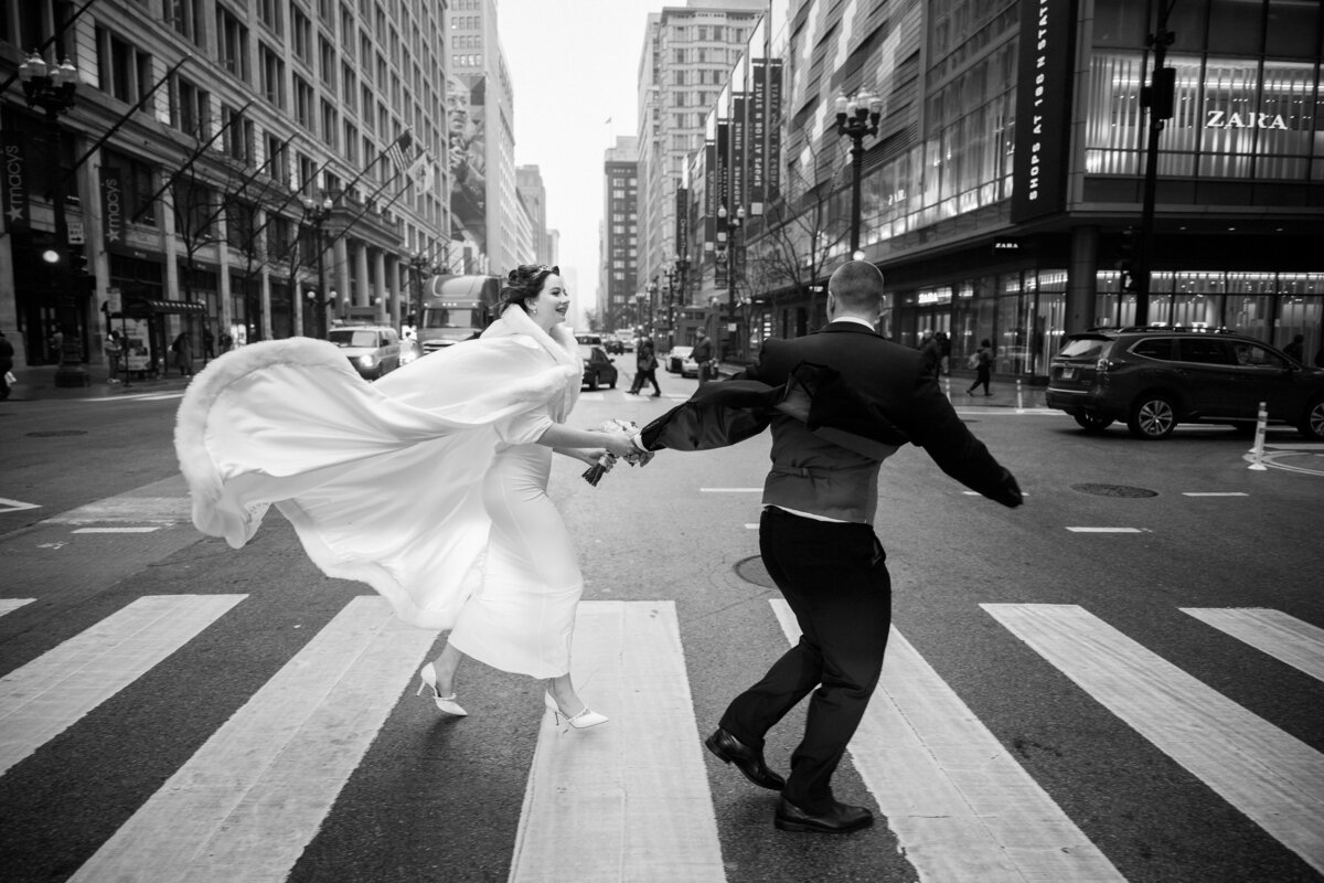 Documentary style black and white image of newlyweds running in the street of Chicago