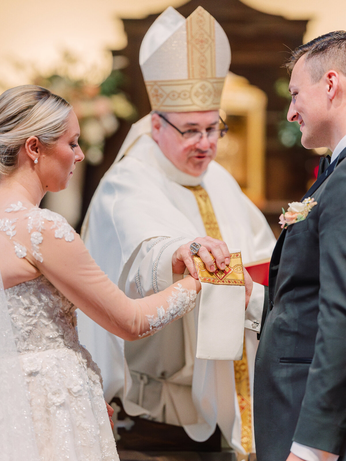 Closeup of a priest performing a traditional Catholic handfasting during wedding Mass