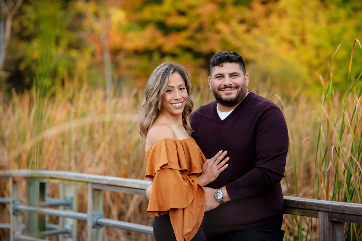 Husband and wife standing on a bridge for their fall Burlington, On family photographer session