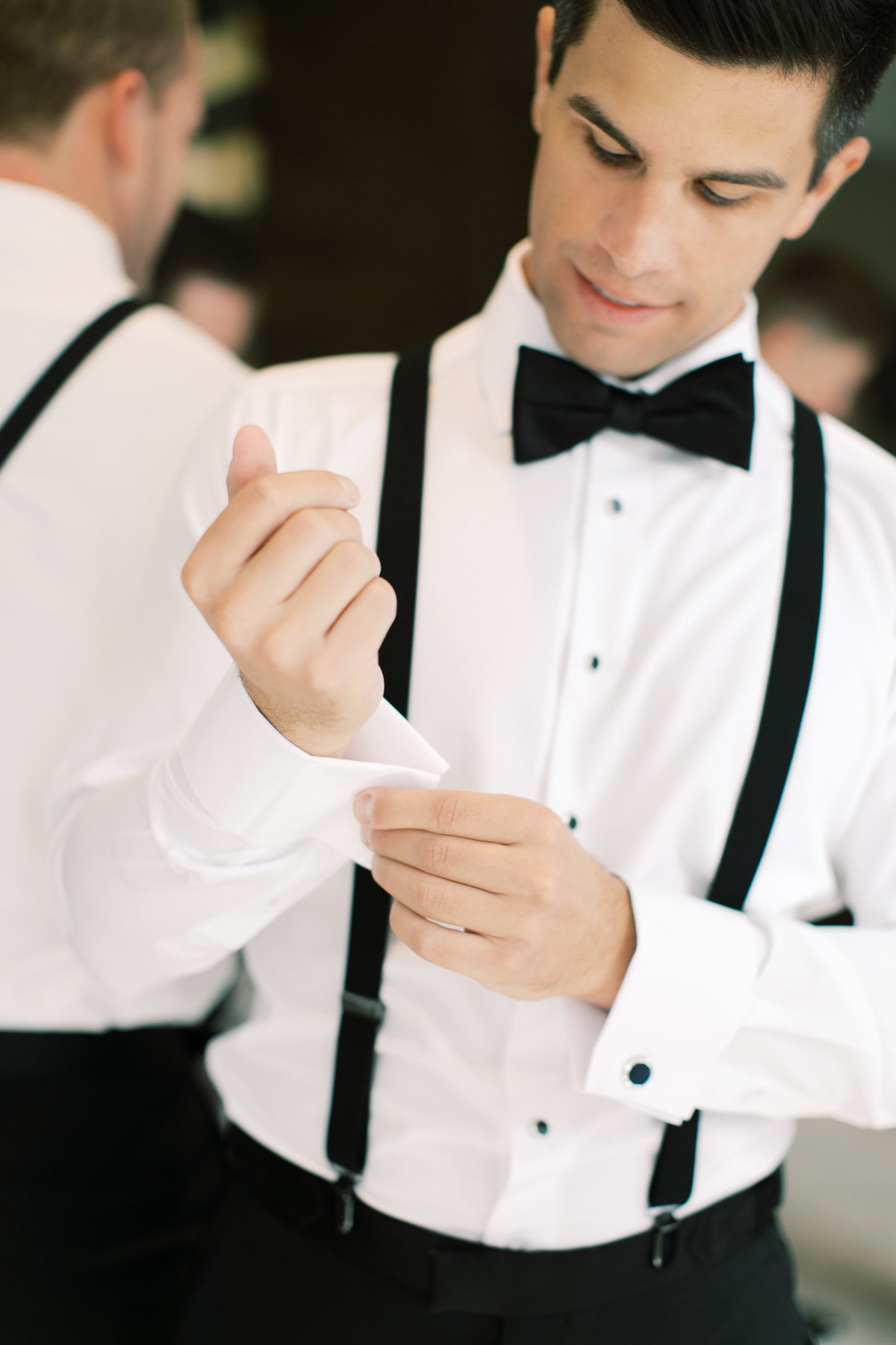 groom adjusting sleeves and buttoning sleeves