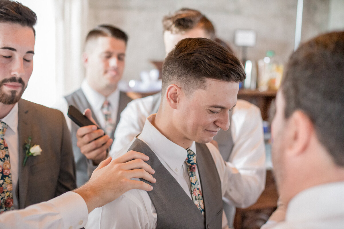 Austin's groomsmen surround him; and lay hands on him, blessing his wedding day.  Captured by Stephanie Eddy, Boulder wedding photographer.