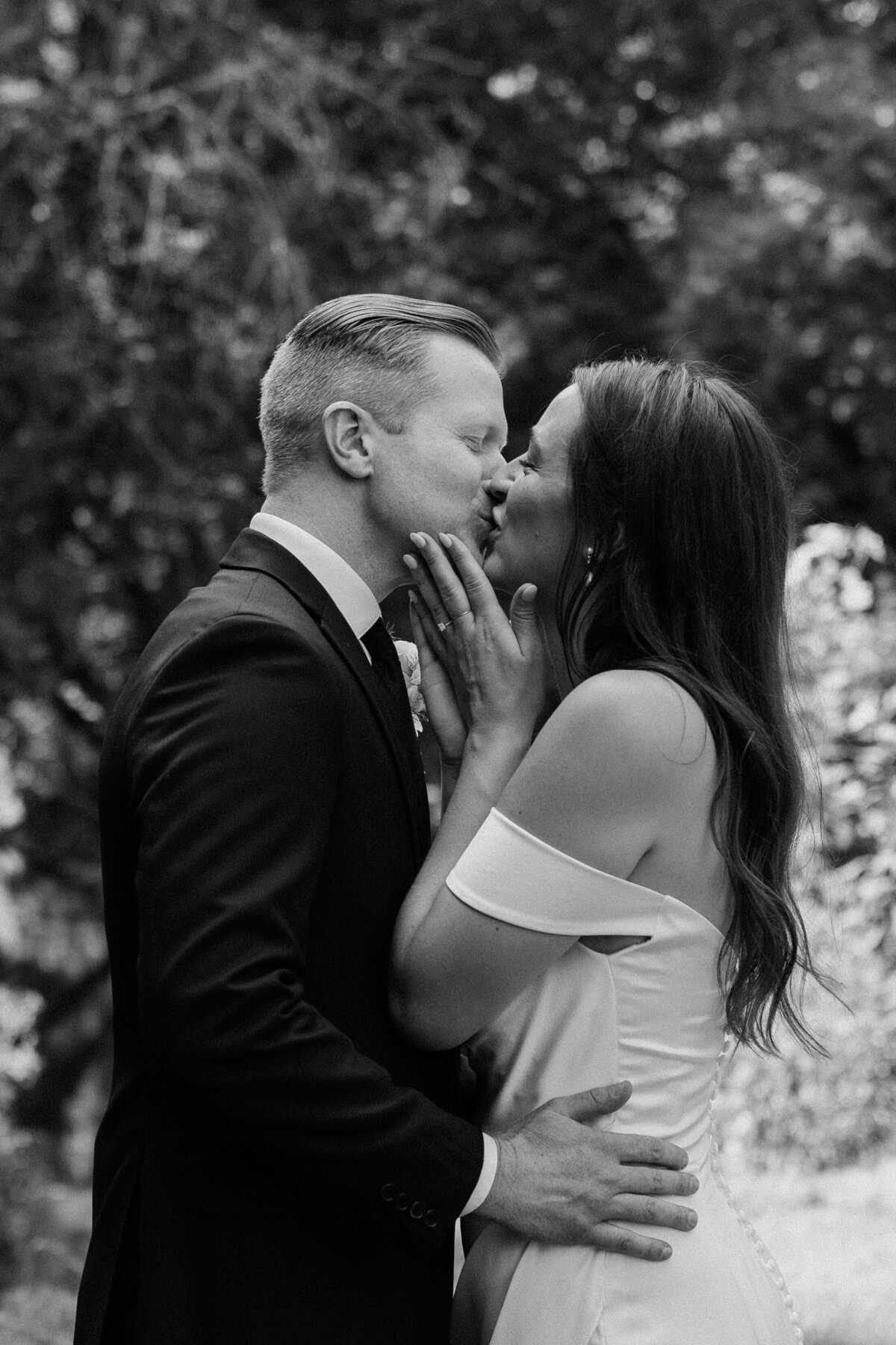 The bride and groom sharing a kiss with a smile at the end of their wedding ceremony